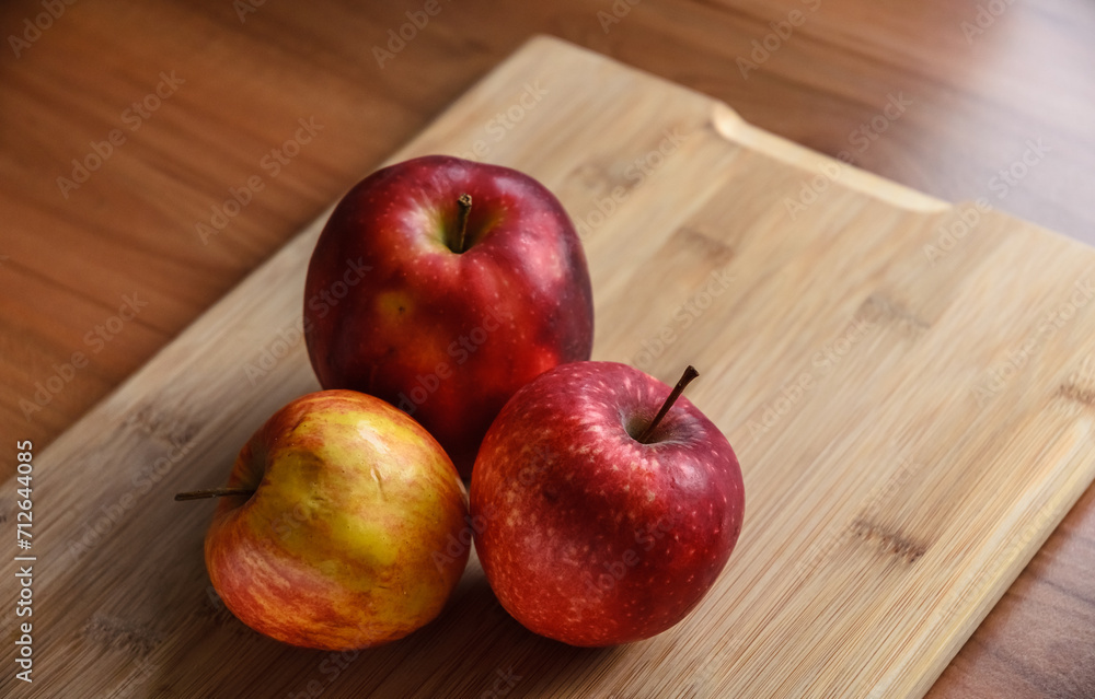 Red and yellow apples on wooden cutting board in the kitchen, healthy diet Vitamin C fruit Red and yellow apples on wooden cutting board in the kitchen, healthy diet Vitamin C fruit
