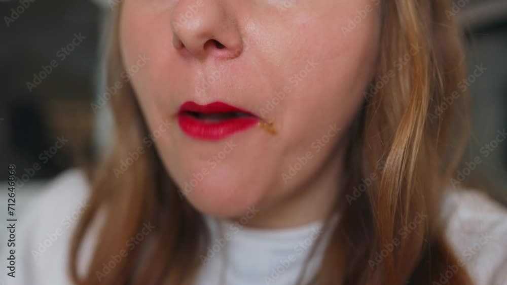 Cropped video of woman in white t-shirt with red lipstick smudge, eating fried chicken, nuggets at kitchen at cozy home. Cropped video of woman in white t-shirt with red lipstick smudge, eating fried chicken, nuggets at kitchen at cozy home.