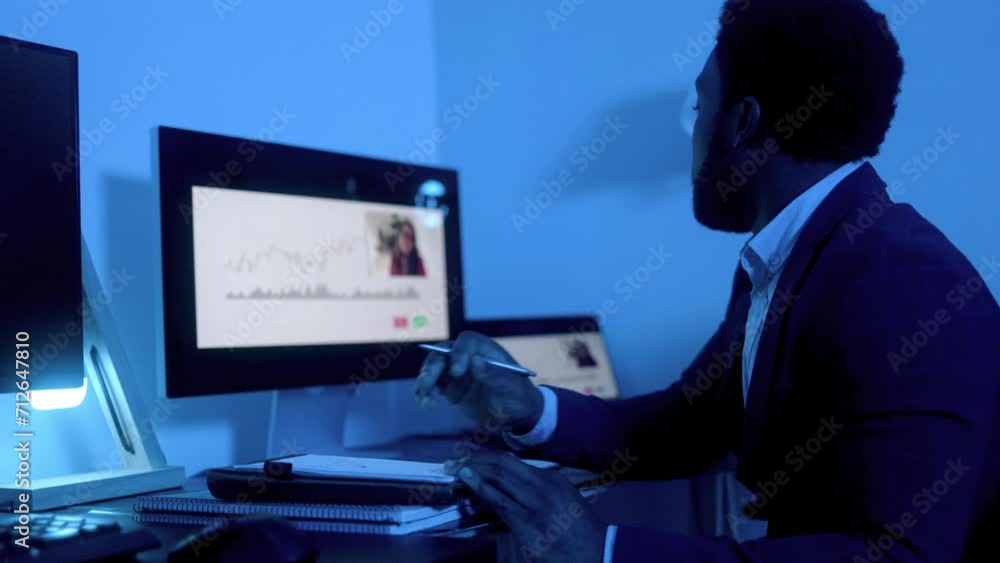 Business African trader investor making stock market analysis video call inside office at night - Financial broker economic concept Business African trader investor making stock market analysis video call inside office at night - Financial broker economic concept