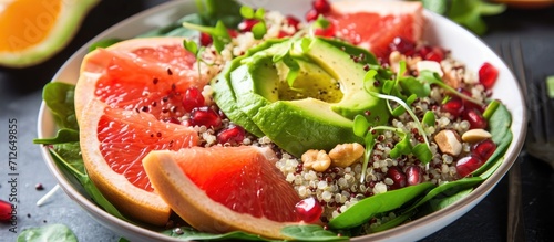 Vegan winter salad made by the chef with quinoa, spinach, avocado, grapefruit, pomegranate, nuts, and microgreens.