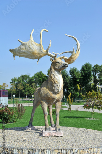 Pidhirya village, Ivano-Frankivsk region, Ukraine - September 26, 2023: Concrete sculpture of the elk (Megaloceros giganteus), one of the largest deer that ever lived. Land History Park. photo