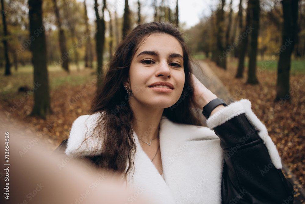Attractive pretty woman make selfie outdoor, portrait of young lady in warm sunny autumn park season, fall, yellow orange red leaves, dressed leather wool fur jacket smiling having fun
Attractive pretty woman make selfie outdoor, portrait of young lady in warm sunny autumn park season, fall, yellow orange red leaves, dressed leather wool fur jacket smiling having fun