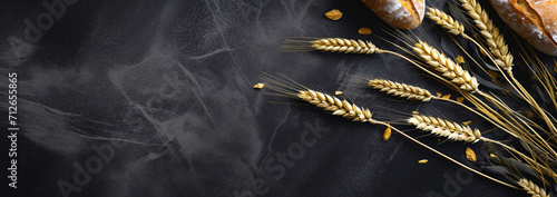 wheat stalks and bread on a stone table photo