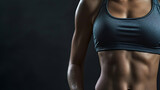 Detail of the muscular waist of a female athlete in sportswear. Black background and space for text. Fitness and gymnastics concept.