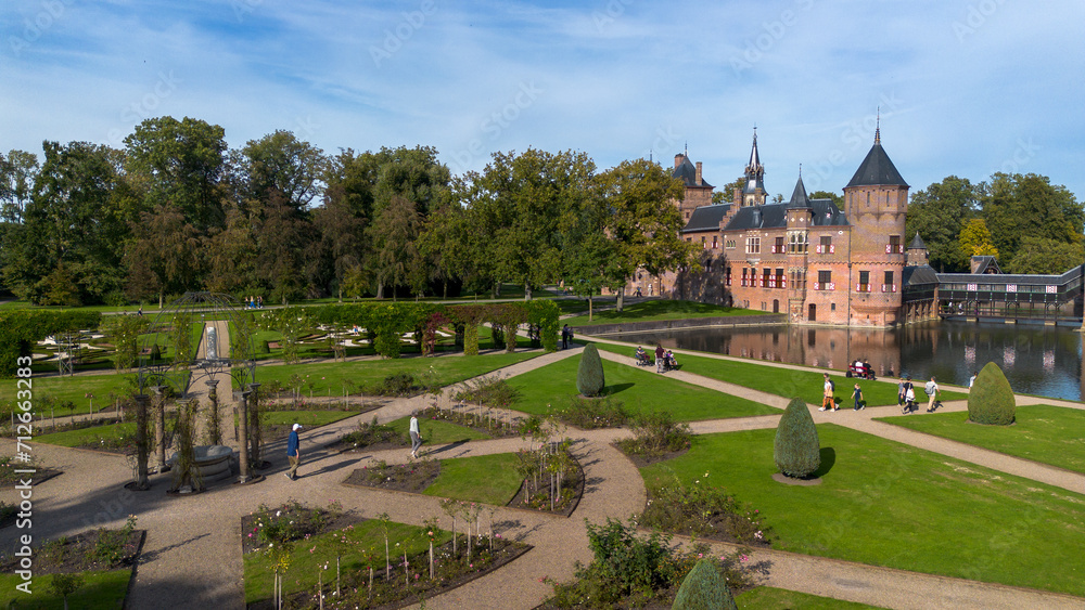 Fototapeta premium Top view of the largest castle in the Netherlands, De Haar. A beautiful quadcopter flight over the castle, the park and the water moat around the castle. A beautiful park in English style.