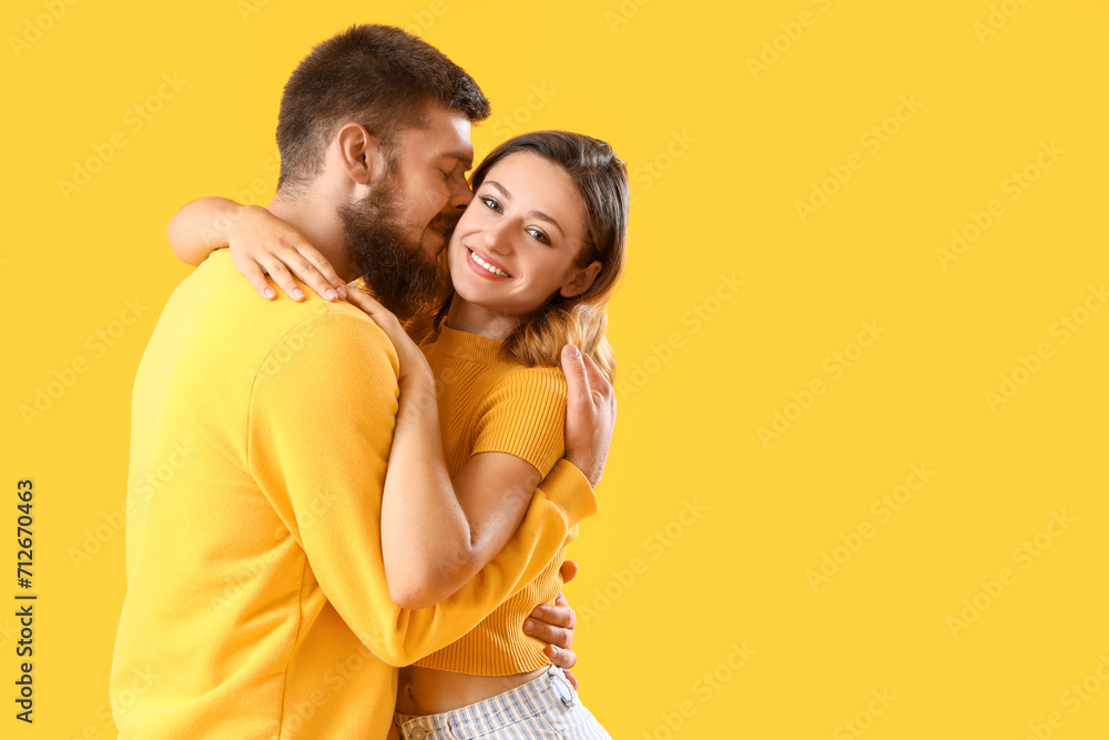 Happy couple in love hugging on yellow background Happy couple in love hugging on yellow background