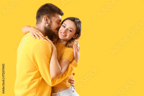 Happy couple in love hugging on yellow background © Pixel-Shot