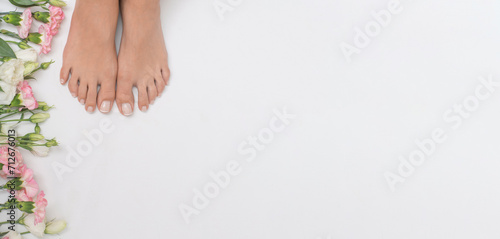 Beautiful female feet with flowers in the background.