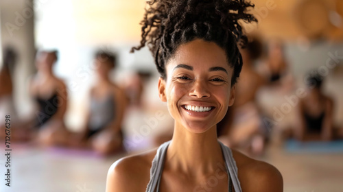A woman smiles for the camera while standing in a yoga class