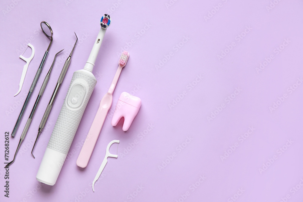 Toothbrushes, dental tools, tooth model and floss toothpicks on lilac background. World Dentist Day Toothbrushes, dental tools, tooth model and floss toothpicks on lilac background. World Dentist Day