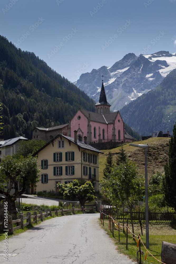 View of Trient village and pink church in Martigny, Valais in Switzerland. With beautiful mountains in the background. It is a popular tourist destination in the Swiss Alps.
