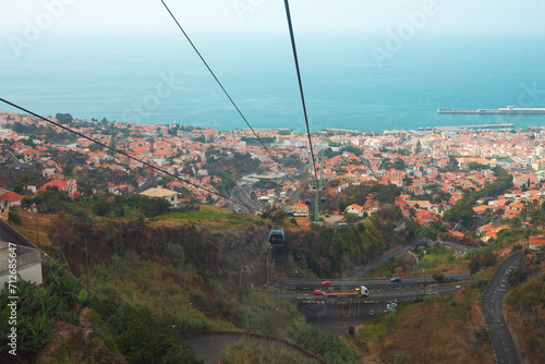 Panoramic view of the cable car on the picturesque background of the gorge and the city of Funchal in the distance. Copy space.