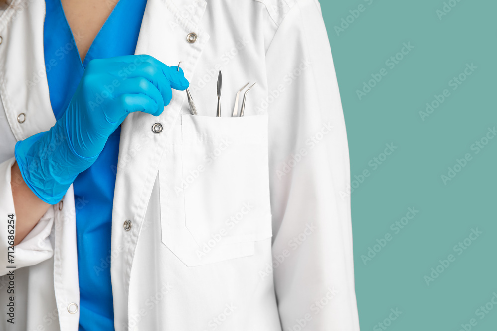 Female dentist with dental tools in pocket on blue background, closeup. World Dentist Day Female dentist with dental tools in pocket on blue background, closeup. World Dentist Day