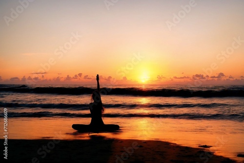 Young woman practicing yoga on the beach at sunrise. Yoga concept.