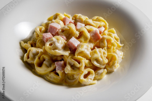 Soup bowl with tortellini pasta with cream and ham