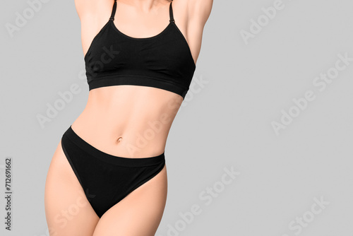 Sexy young woman in black cotton underwear on light background
