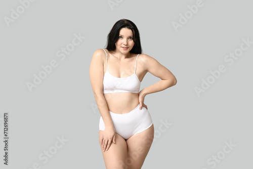 Body positive woman in underwear on light background © Pixel-Shot