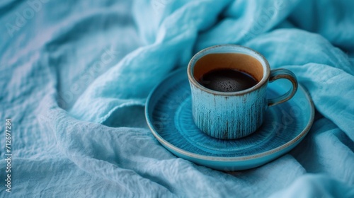 a cup of coffee sits in an empty cup, blanket, and saucer,