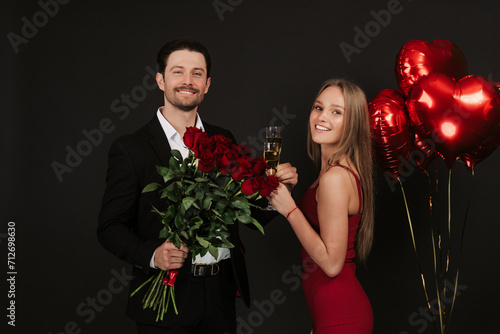 True love. Beautiful young couple drinking champagne and smiling while sitting face to face