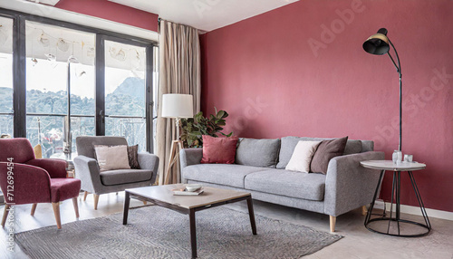 Stylish grey sofa and armchairs against pink and crimson wall with copy space. Minimalist japandi home interior design of modern living room.