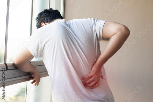 Man suffering from back ache. Man holding back, having problem with standing up. Healthcare and problem concept