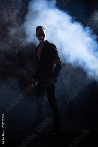 Silhouette of a man on a black background in clouds of smoke.