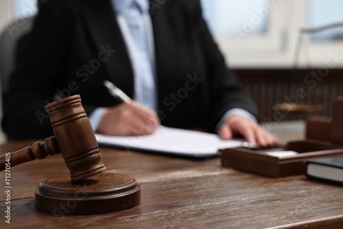 Lawyer working at wooden table in office, focus on gavel