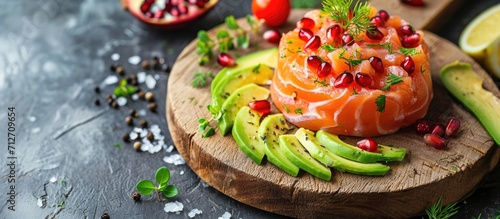 Salmon, avocado, and pomegranate tartare displayed on a wooden board