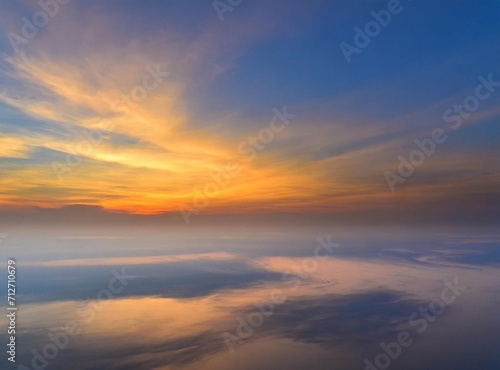 Sunrise on the sky, view from an airplane. Travel background/wallpaper with orange clouds and copy space. © D'Arcangelo Stock