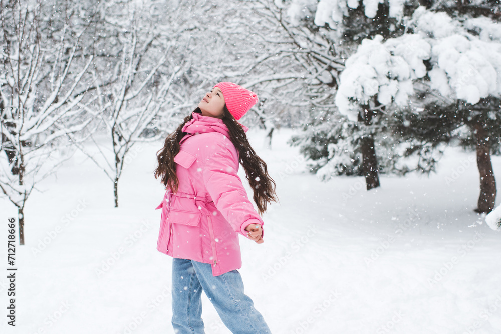 Cute teenage girl 14-15  year old having fun in snow outdoor. Winter holiday season.