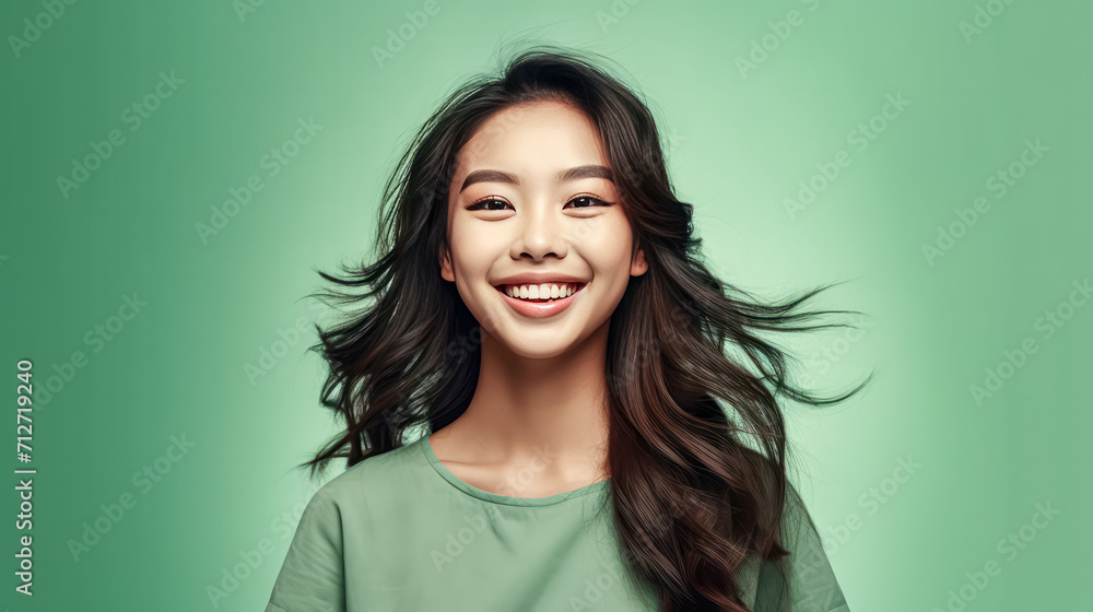 a girl of Asian appearance brightens a green background. a girl of Asian appearance brightens a green background.