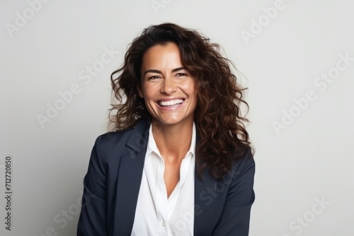 Portrait of a happy businesswoman smiling at the camera on gray background