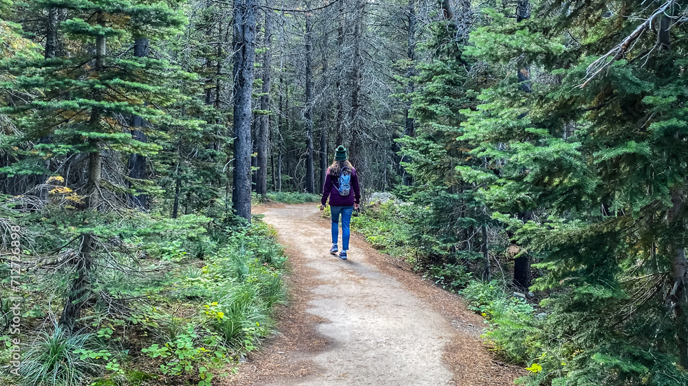 Woman Hiking around Swiftcurrent Lake in Many Glacier Region of Glacier National Park Woman Hiking around Swiftcurrent Lake in Many Glacier Region of Glacier National Park