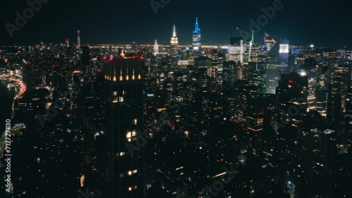 Illuminated Manhattan USA. New York City views background. Aerial Time Square downtown panorama. Drone flight above high skyscrapers building after dark.Scenic night time areal above modern night city