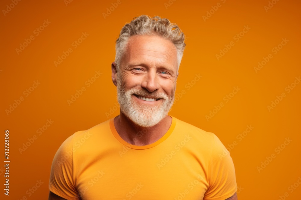 Handsome mature man in orange t-shirt on orange background Handsome mature man in orange t-shirt on orange background