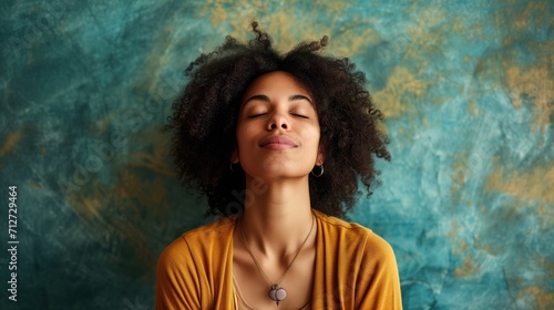 A serene young woman with closed eyes against a textured turquoise backdrop © olz