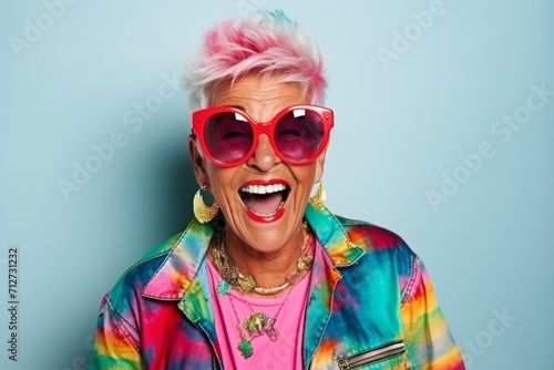 Portrait of a beautiful senior woman with pink hair and sunglasses.