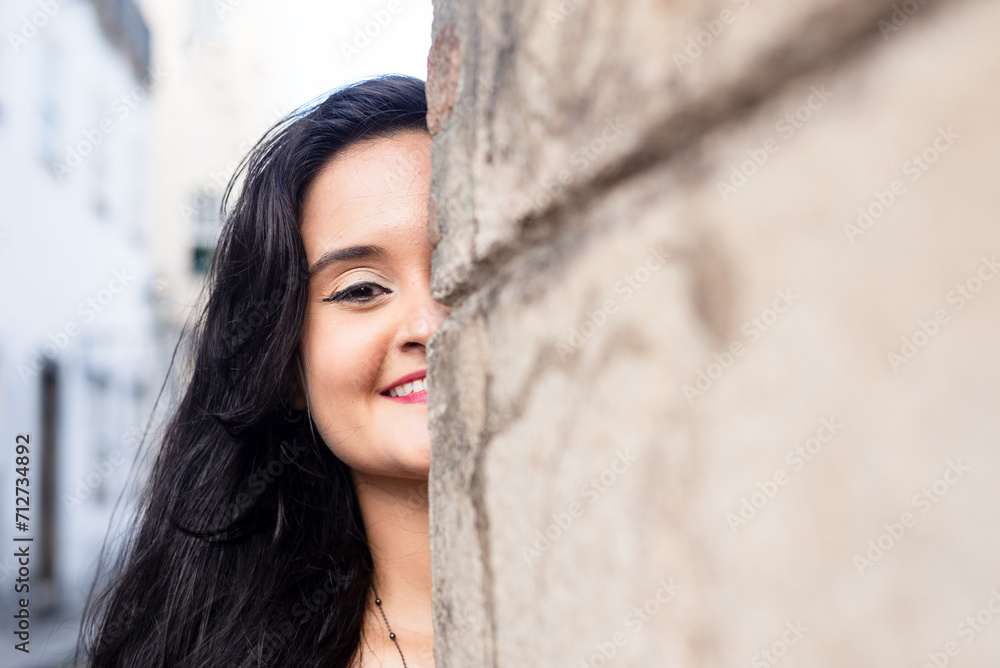 Close-up portrait of half the face of a beautiful woman, with black hair, outdoors leaning against a cement wall. Close-up portrait of half the face of a beautiful woman, with black hair, outdoors leaning against a cement wall.
