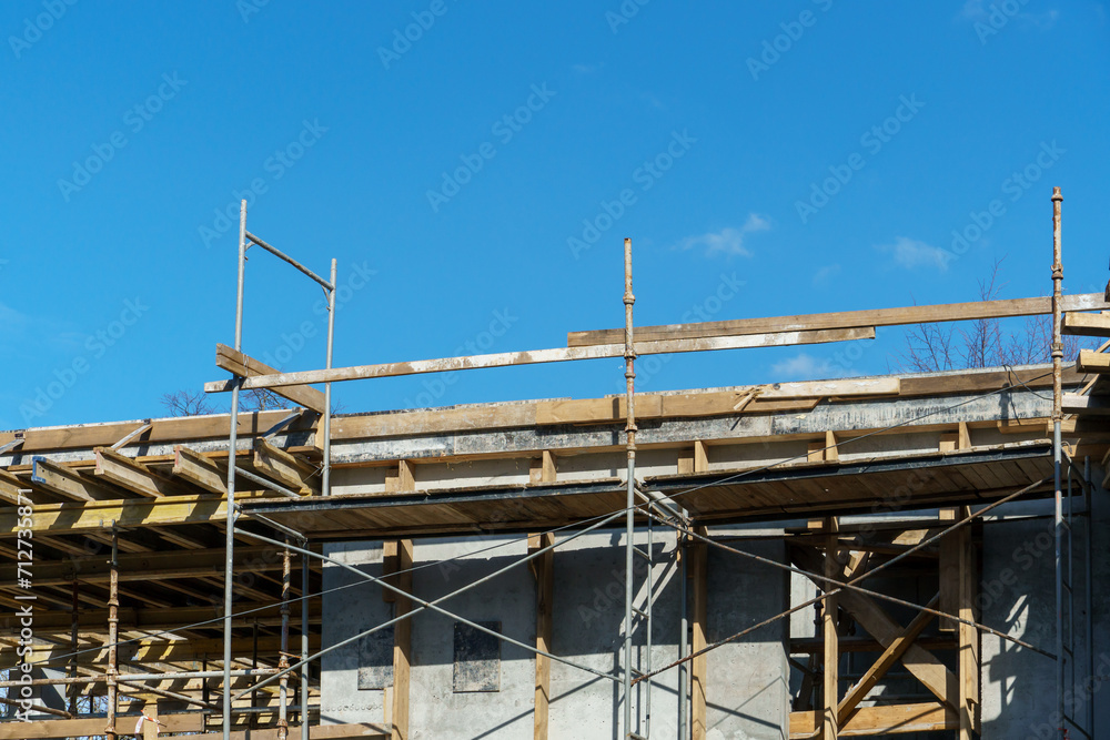 An outdoor construction site. Construction of a new building. Block construction, reinforced concrete beams and wooden floors and roofs.