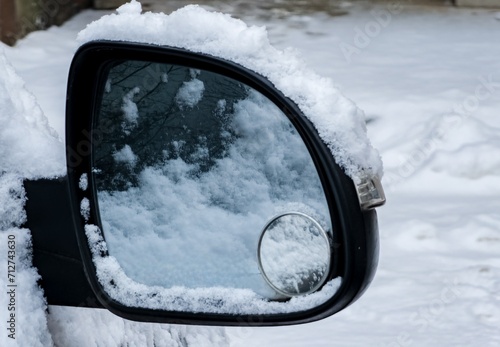 Close-up of a side mirror of a modern car covered in snow © Nataliia