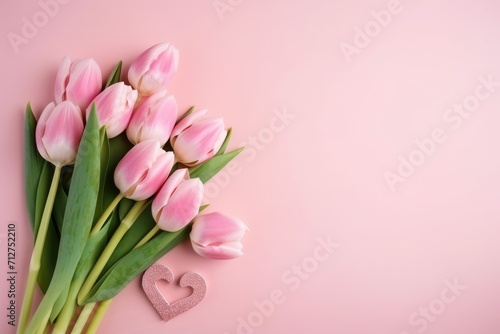 A bouquet of pink tulips on pink background with space for text. Greeting card for valentine s day or mother s day