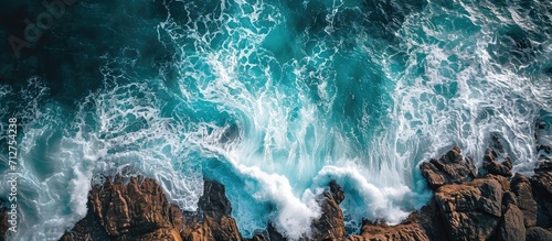 Bird's-eye view of waves crashing on rocks. photo