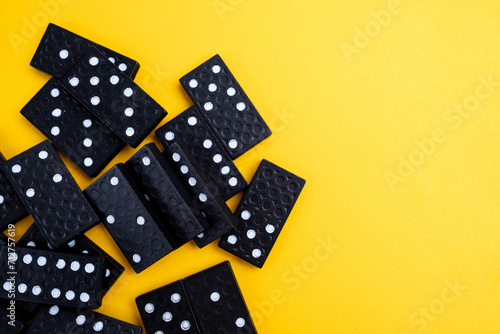 Black domino on a yellow background. Domino effect concept. Business, risk, management and finance concept photo