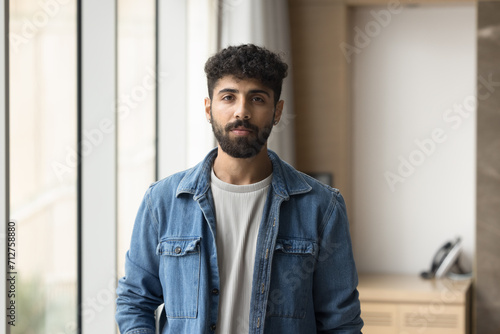 Fotografia Serious handsome business company owner man in informal casual clothes posing in office for shooting, looking at camera