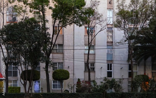 Wallpaper Mural Classically styled apartment building, behind a tree-lined avenue in the afternoon. Torontodigital.ca