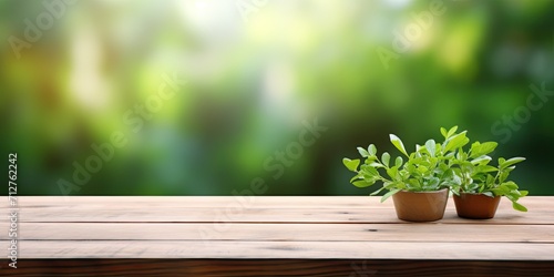 Wooden tabletop with green blurred background - ideal for product display or montage.