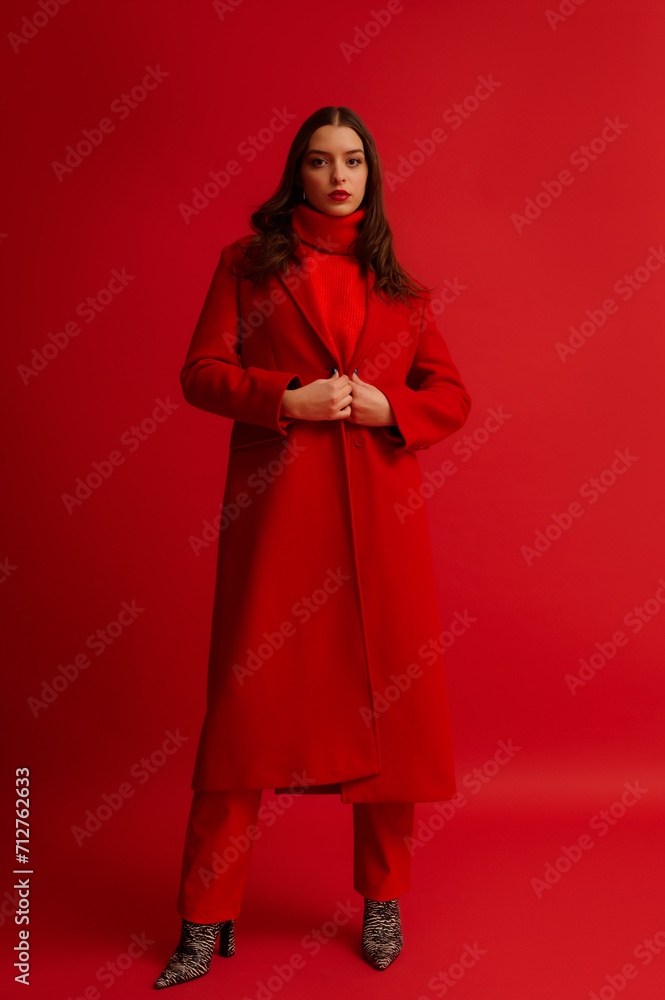 Fashionable confident woman wearing trendy red midi coat, turtleneck sweater, leather pants, zebra print boots, posing on red background. Full-length studio fashion portrait
Fashionable confident woman wearing trendy red midi coat, turtleneck sweater, leather pants, zebra print boots, posing on red background. Full-length studio fashion portrait
