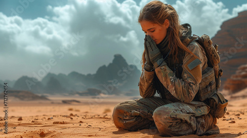 A female soldier praying in the desert