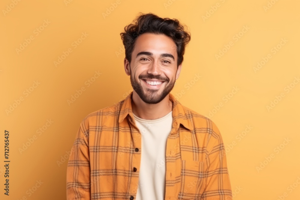 Portrait of a handsome young man smiling at camera over yellow background Portrait of a handsome young man smiling at camera over yellow background