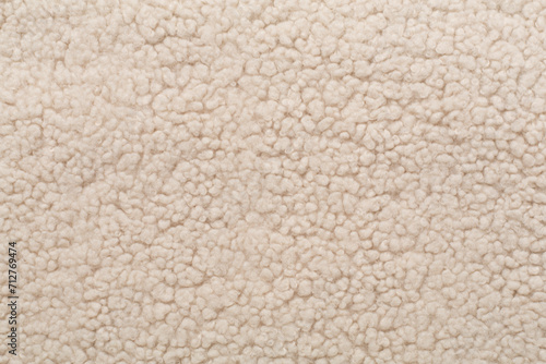 Beige cuddle teddy bear fabric as background, top view